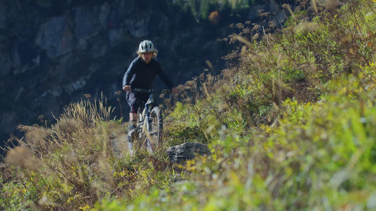 un ciclista de montaña está recorriendo un sendero alpino expuesto en otoño