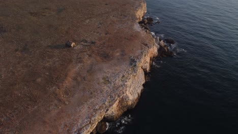 無人機從上向下觀看海浪在岩石海岸的噴射,背景