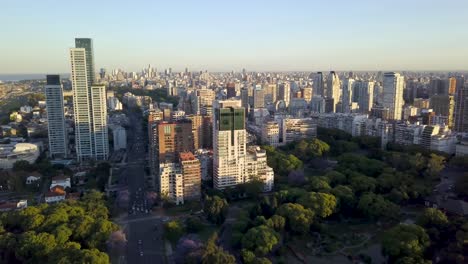 aerial of beautiful buenos aires cityscape flying over bosques de palermo at sunset
