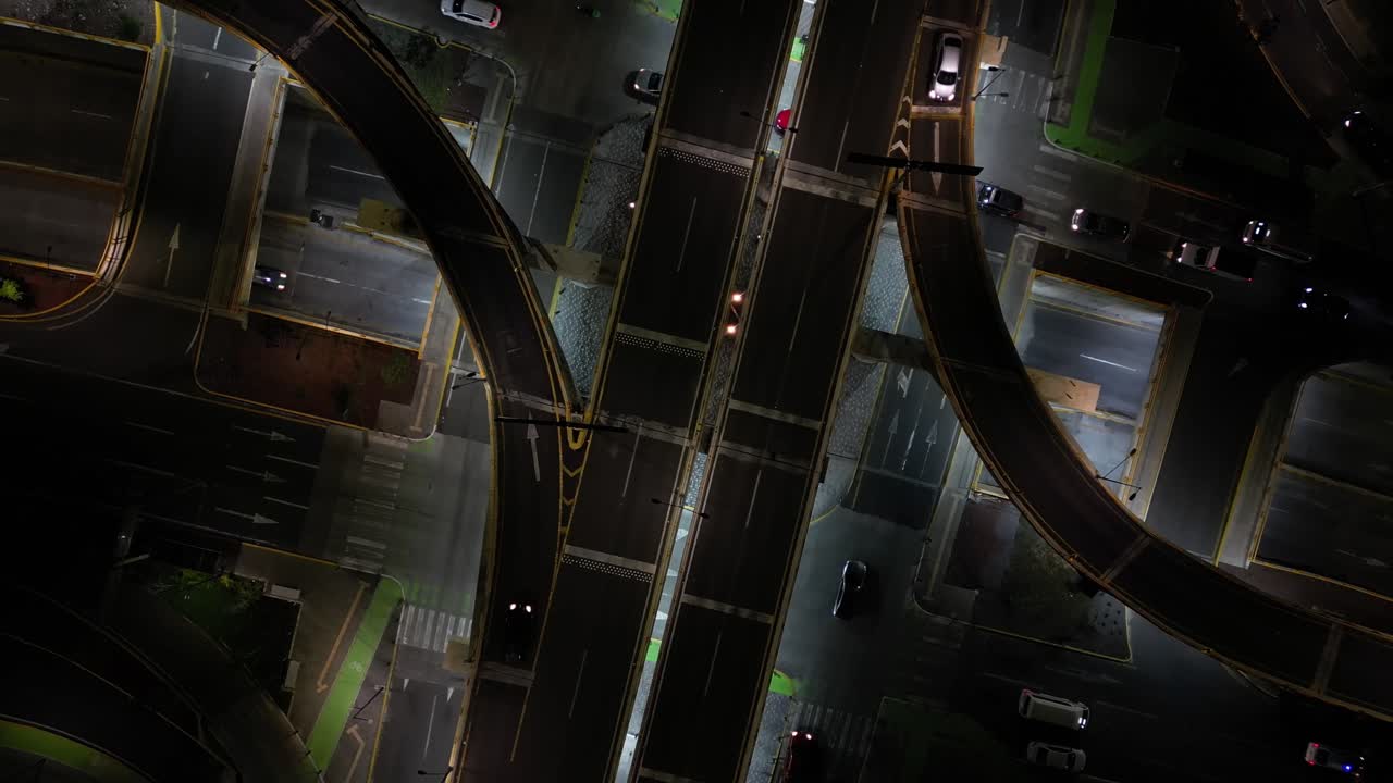Heavily trafficked car intersection, at night, shot with a drone. In Morelia