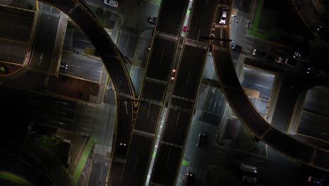 heavily trafficked car intersection, at night, shot with a drone. in morelia