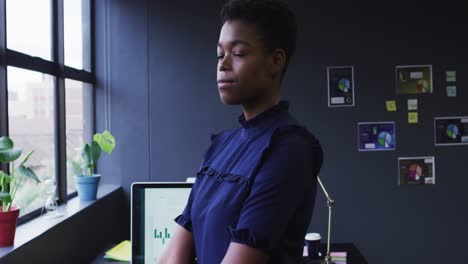 Portrait-of-african-american-businesswoman-standing-looking-at-camera-in-modern-office