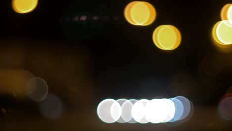 Semáforos-De-Coche-Bokeh-En-Movimiento-En-La-Ciudad-Durante-La-Noche