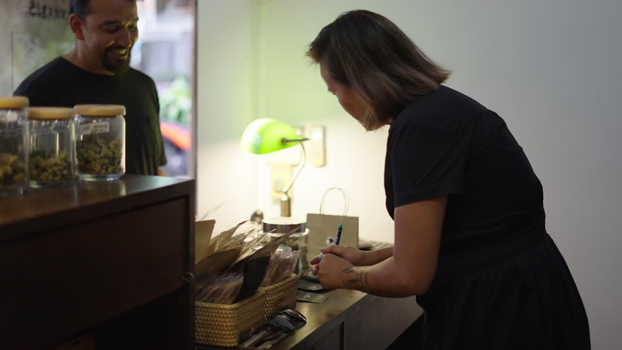 Customer signing at a cannabis dispensary counter