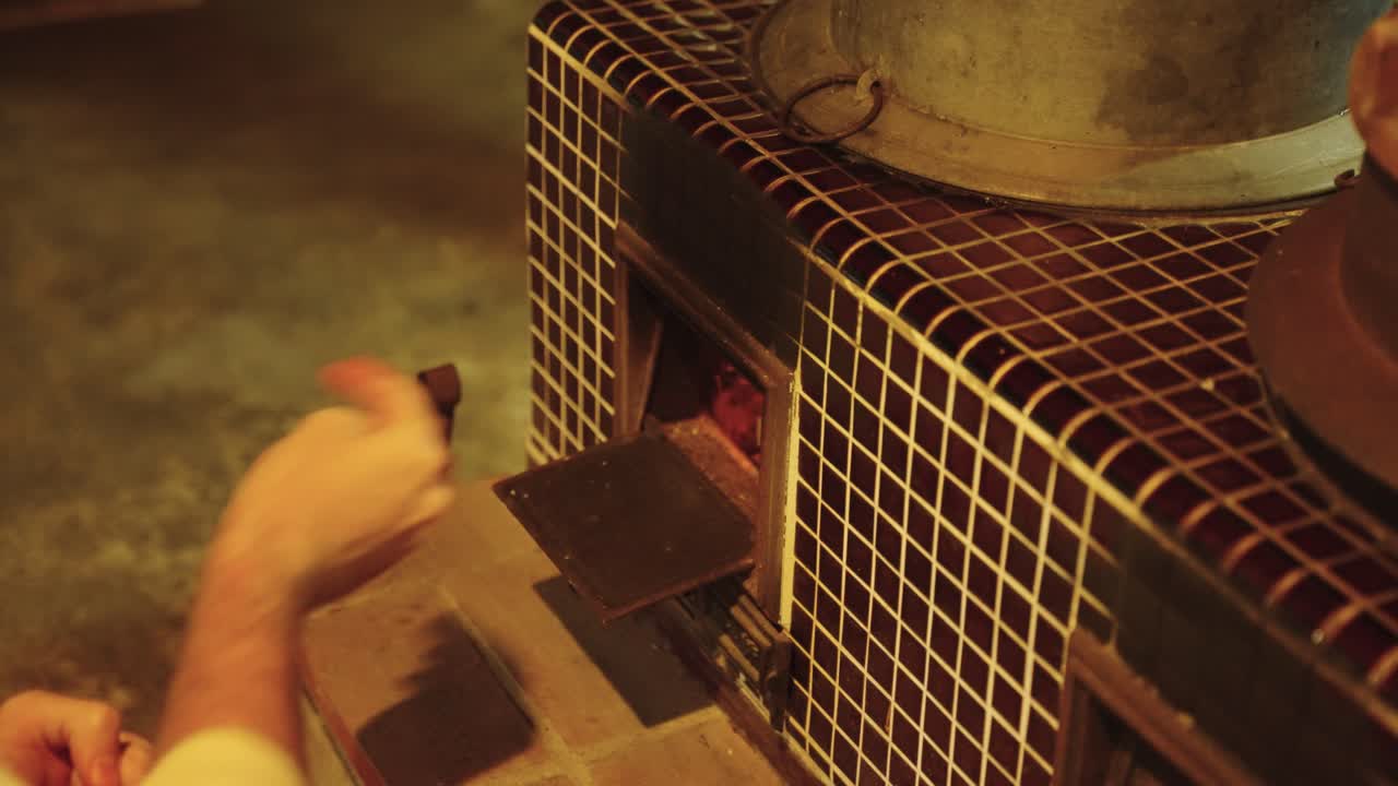 코민카 하우스 4k에서 구식 스토브에 손으로 나무를 공급하는 것