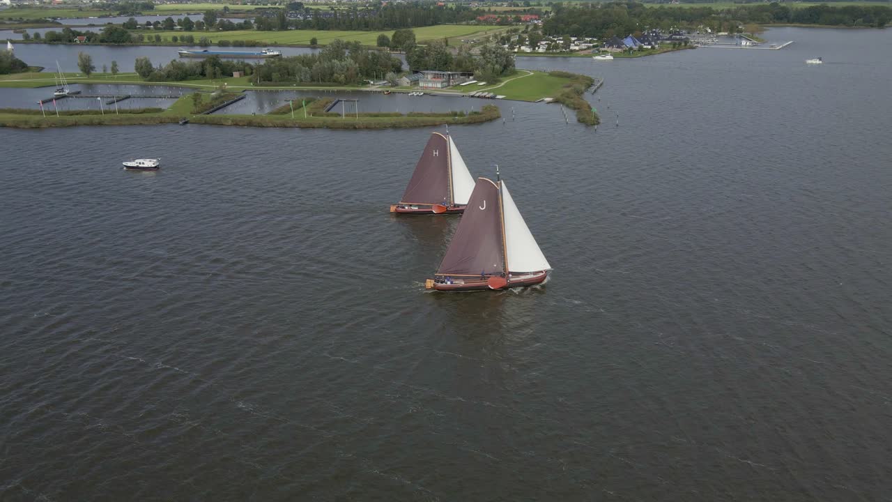 Letecký pohled na tradiční plachetnice skutsje závodící na jezeře Sneekermeer ve Sneeku, Frísku, Nizozemsku