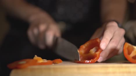 chef cutting and slicing red capsicum into julienne's cut using a sharp knife