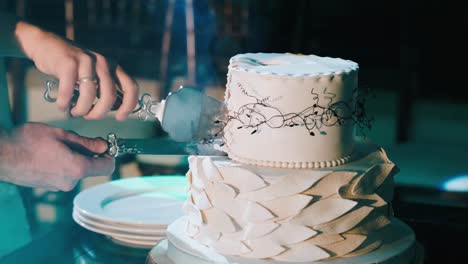 The-hands-of-the-newlyweds-hold-a-knife-cut-the-wedding-cake