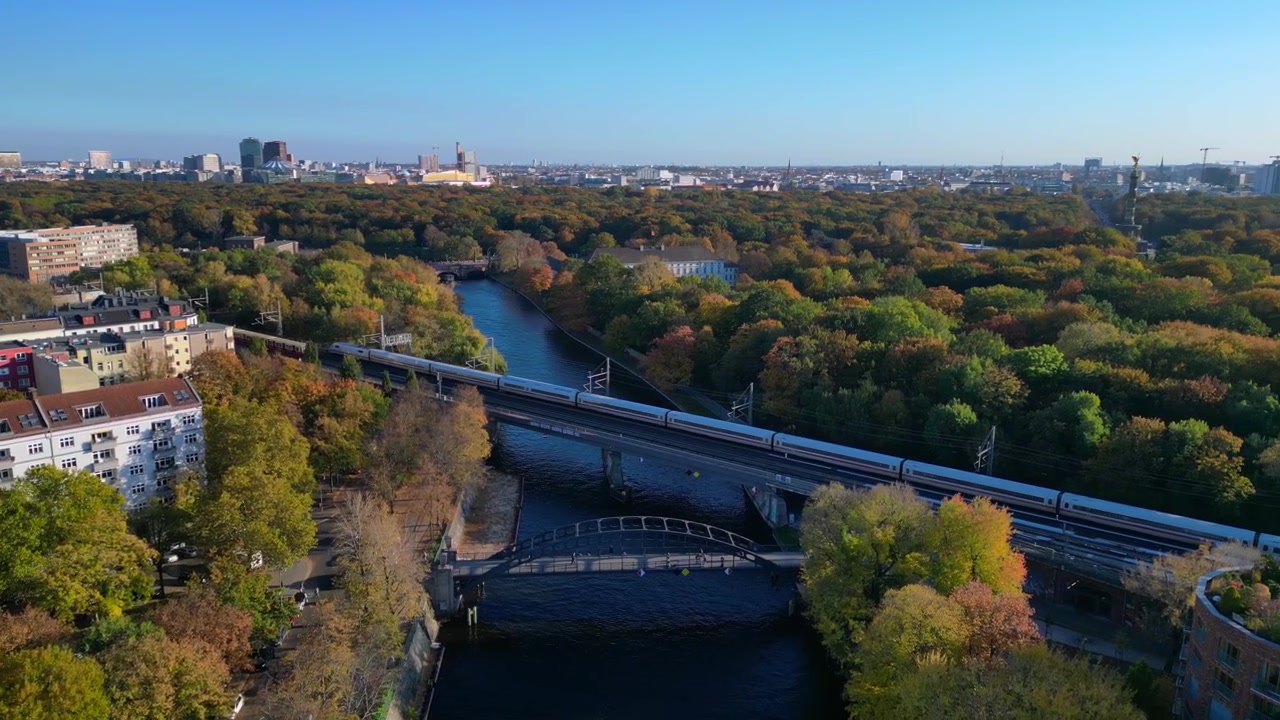 Landwehrkanal i Berlin, Tyskland, omgivet af bygninger og efterårstræer på en solrig dag. Flot luftfoto med rotation til højre fra drone.