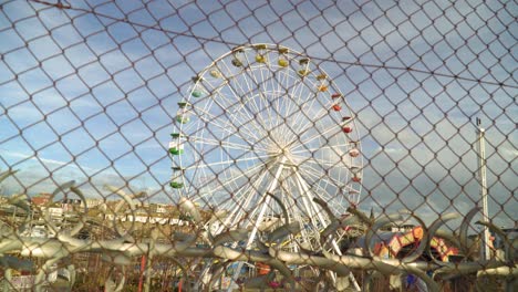 big wheel in amusement park view behind the fence nobody around