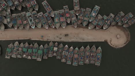 aerial birds eye view of fishing boats moored along jetty at ibrahim hyderi in karachi