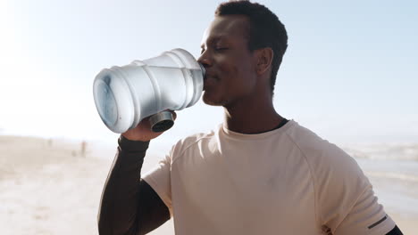 black man, fitness and drinking water on beach