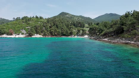 aerial side view of glifoneri beach, with turquoise water and surrounded by luxuriant green foliage, thassos island, greece, europe