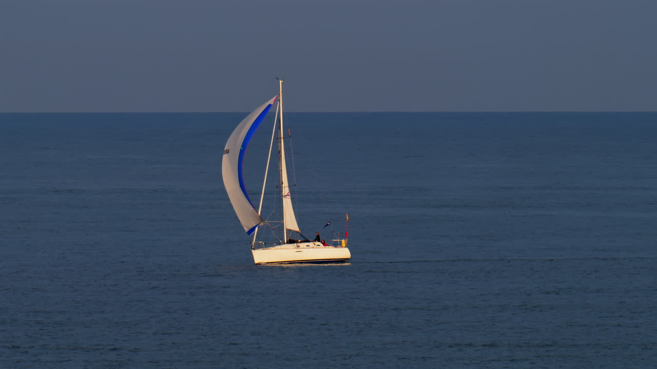 Cannes, France - March 5, 2025: People on a moving sail boat on the sea on a cloudy day