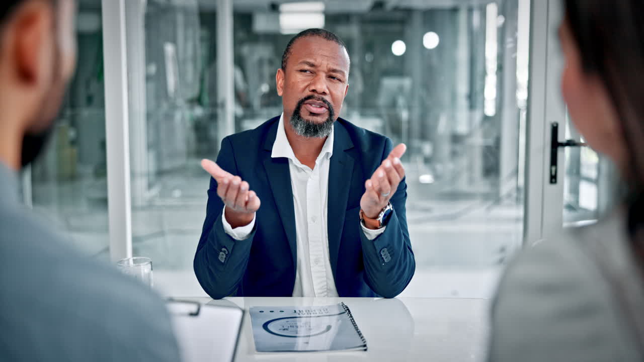 Professional Black Man Speaking and Gesturing in an Office Meeting
