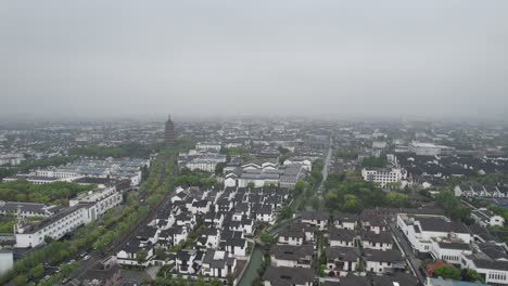 Aerial-pullback-shot-over-residential-area-of-Suzhou-with-pagoda-in-background