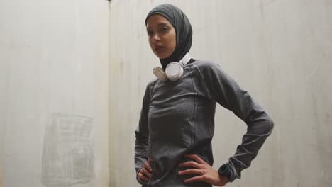 Woman-in-sportswear-with-wireless-headphones-wearing-hijab