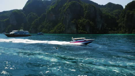 Toma-De-Seguimiento-De-Lancha-Rápida-Moviéndose-A-Través-Del-Mar-Azul-Profundo-En-La-Isla-Ko-Phi-Phi-En-Tailandia