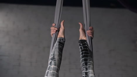 Close-up-of-the-hands-of-a-strong-female-gymnast-holding-the-ropes-before-an-acrobatic-exercise
