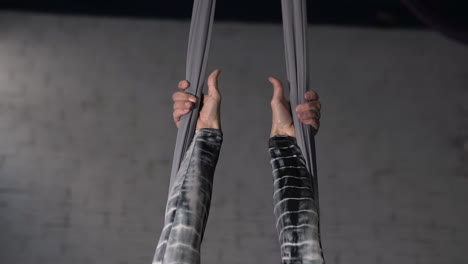 close up of the hands of a strong female gymnast holding the ropes before an acrobatic exercise