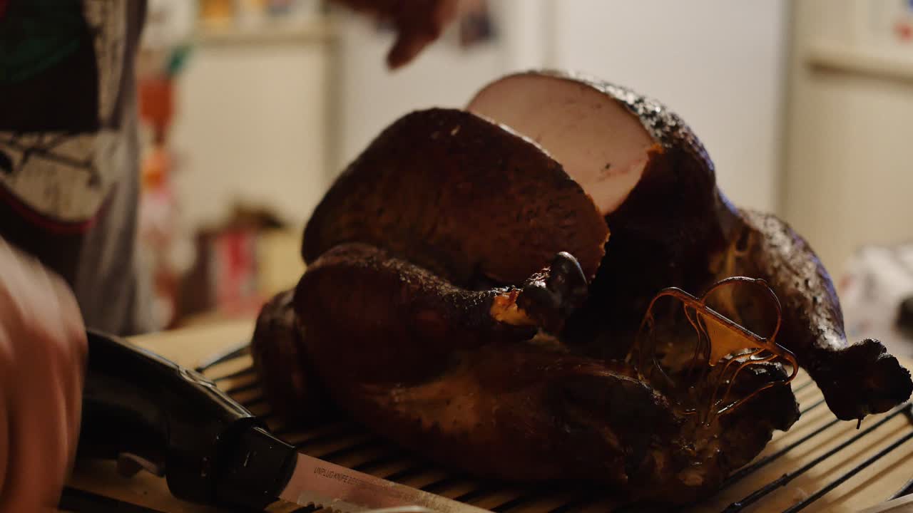 A big chunk of thanksgiving turkey is taken off carcass with electric knife