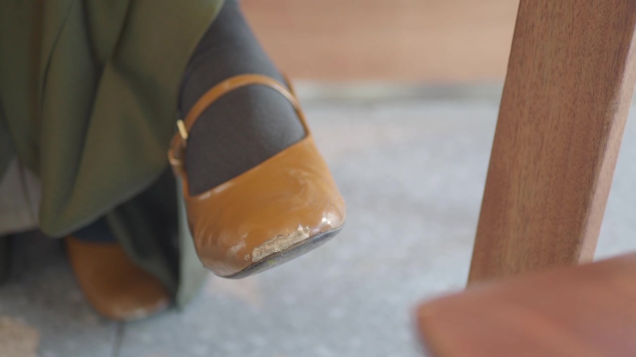 茶色のメリージェーンシューズで足元がタップするクローズアップ