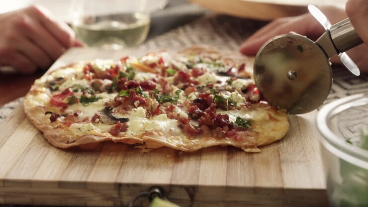 Taglio di una deliziosa pizza fatta in casa