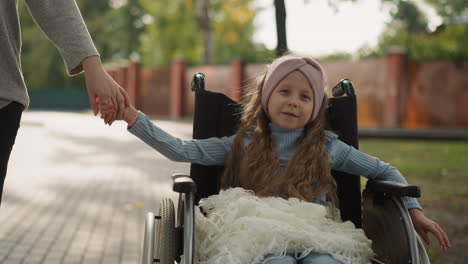 toothless little girl with injury looks at mom holding hand