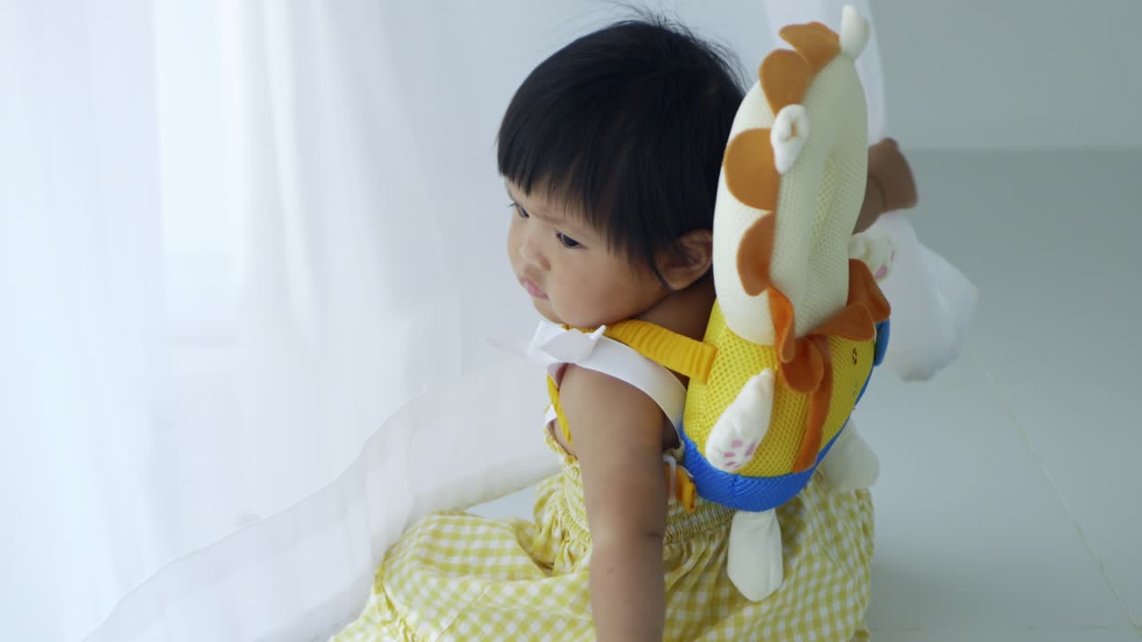 A sweet moment of a baby girl exploring her surroundings with care and curiosity.