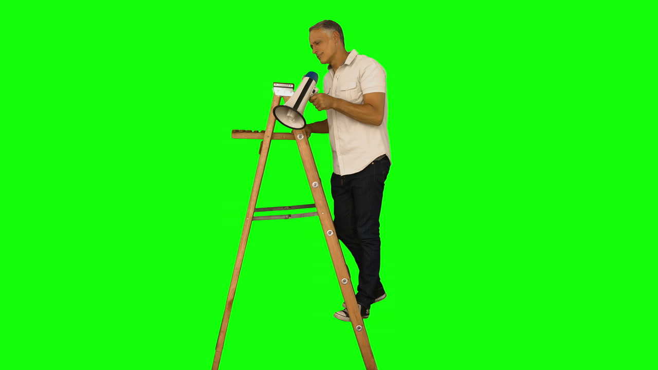 Casual man standing on ladder and shouting 