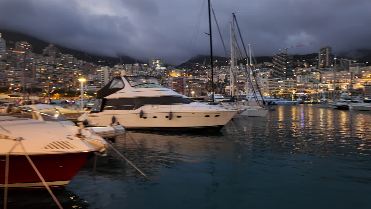 La Condamine, Monaco - 18 luglio 2025: porto affollato di yacht e fitti appartamenti collinari sotto un cielo grigio