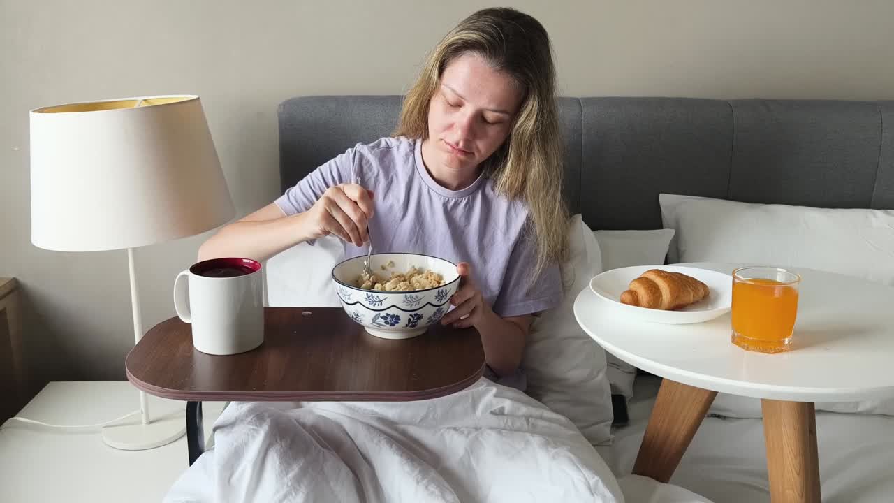 침대에서 아침 식사를 하는 여자