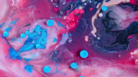 colorful ink swirling in water with a vibrant mix of pink and blue tones, close-up