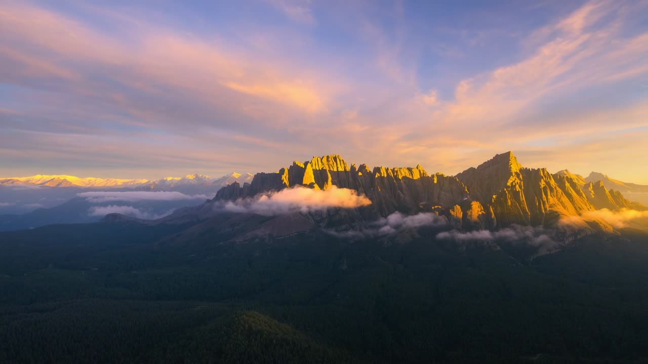 Glowing jagged mountain ridge catching sunrise beam through drifting clouds over forested foothills