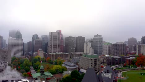 Drone-descending-on-a-spotlight-with-the-beautiful-skyline-of-Montreal-city-on-a-foggy-autumn-morning