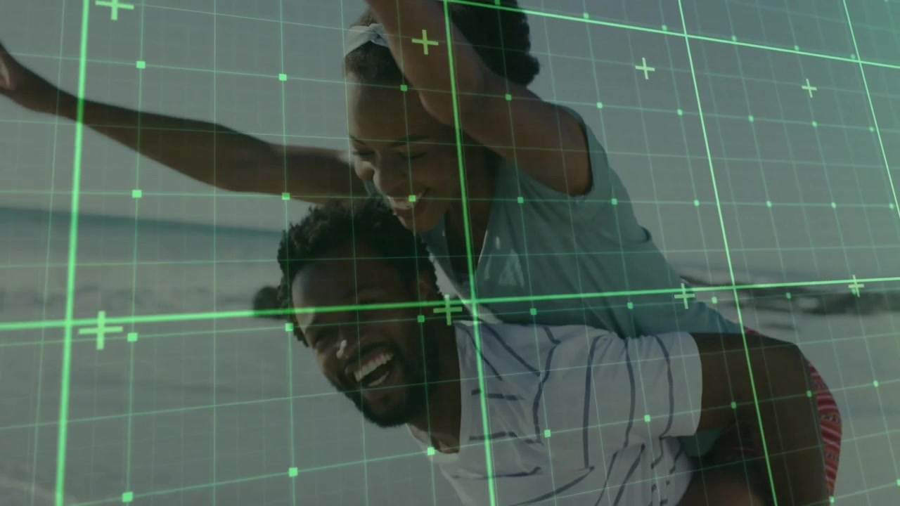 Woman climbing onto man starting walking along shoreline sharing travel fun with green grid overlay