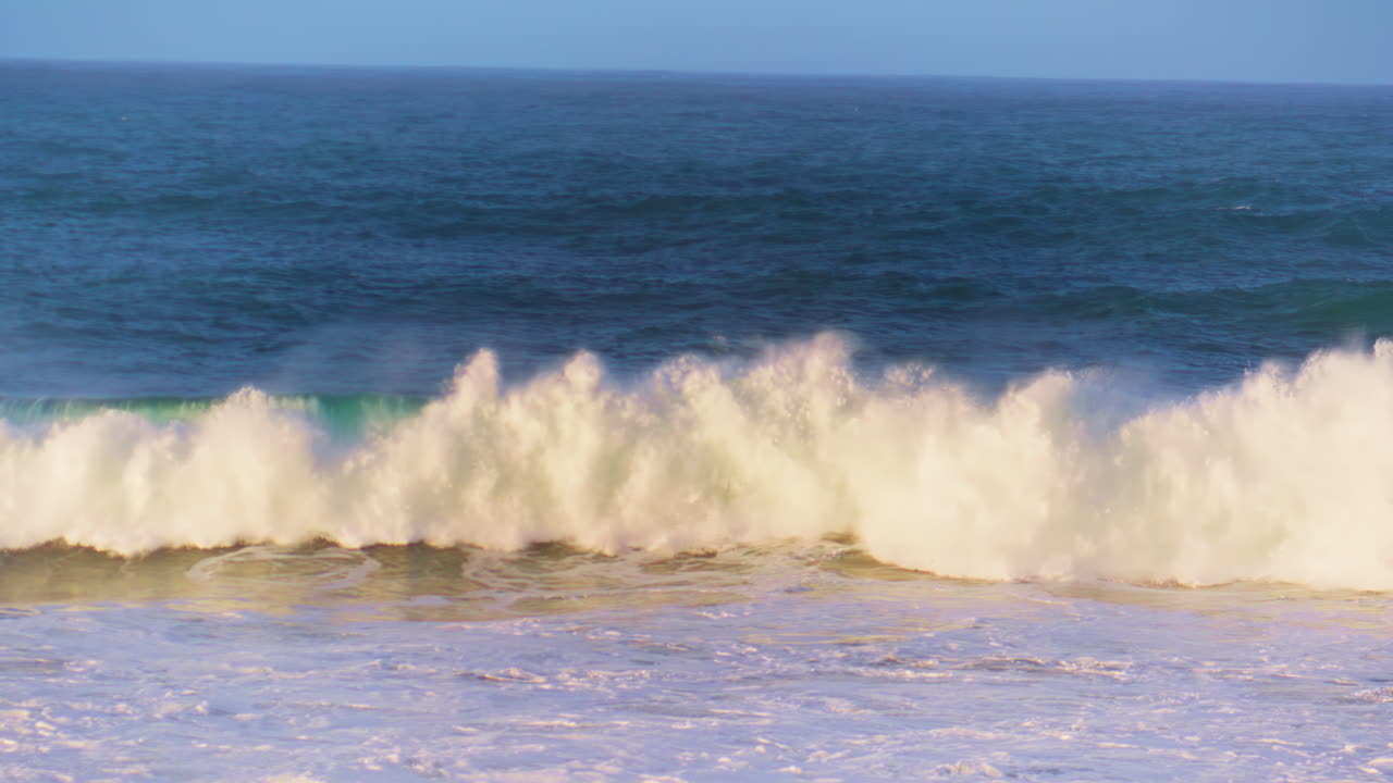 la ola del océano de la mañana rodando hacia poco profundo en movimiento súper lento. espuma de mar blanca