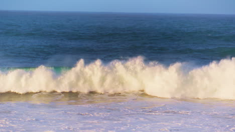la ola del océano de la mañana rodando hacia poco profundo en movimiento súper lento. espuma de mar blanca