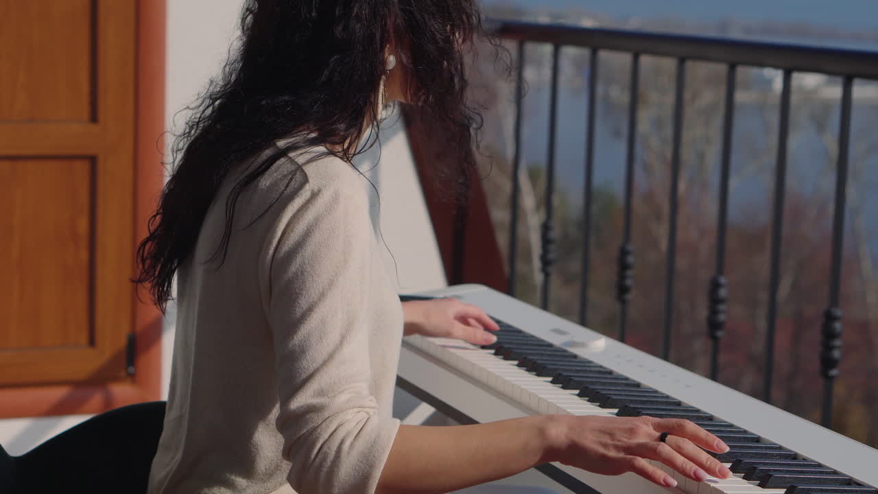 mujer tocando el piano en el balcón
