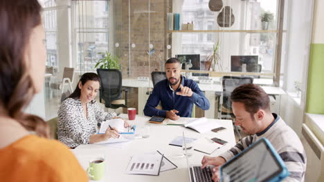 creative business team meeting woman manager presenting financial data to shareholders using digital tablet in casual modern office boardroom with natural light and large open windows