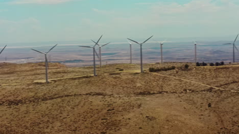 Una-Vista-Panorámica-De-Las-Hileras-De-Molinos-De-Viento-Ubicados-En-La-Cima-De-La-Colina,-Que-Producen-Energía-Limpia-A-Partir-De-Una-Fuente-Renovable