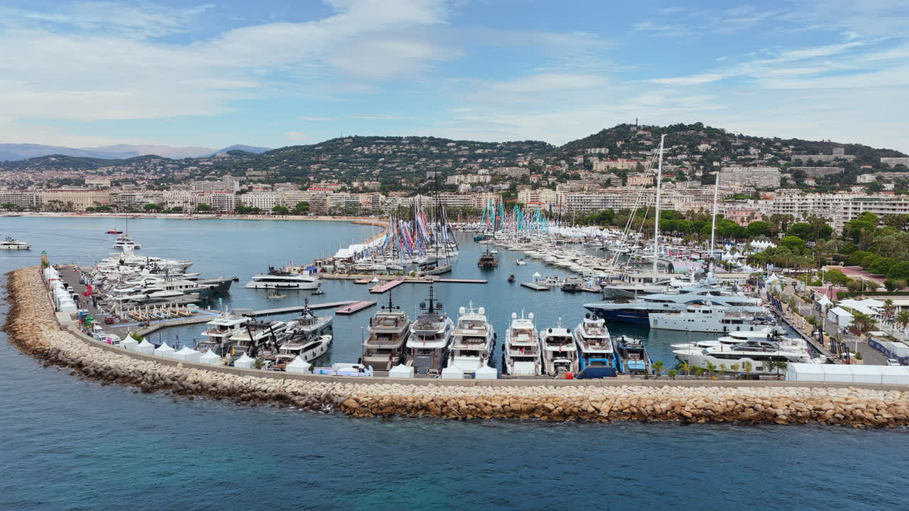 Vista aerea da drone del porto di Cannes pieno di yacht di lusso, barche a vela e hotel sul lungomare sullo sfondo