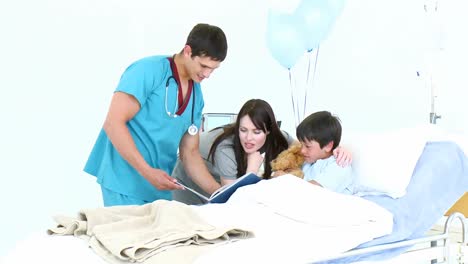 Doctor-reading-a-book-with-a-little-boy-and-his-mother-in-hospital