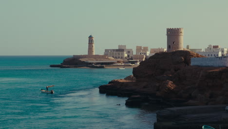 coastal village in oman with lighthouse and fort
