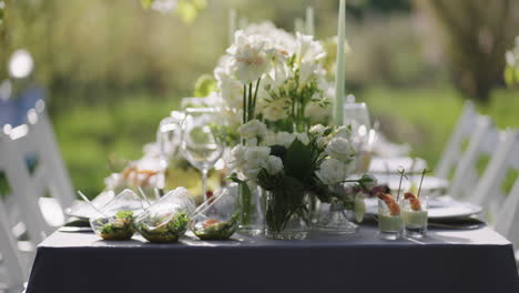 Hermosa-Decoración-Floral-Y-Deliciosos-Aperitivos-En-La-Mesa-En-Un-Jardín-Floreciente-En-Primavera.