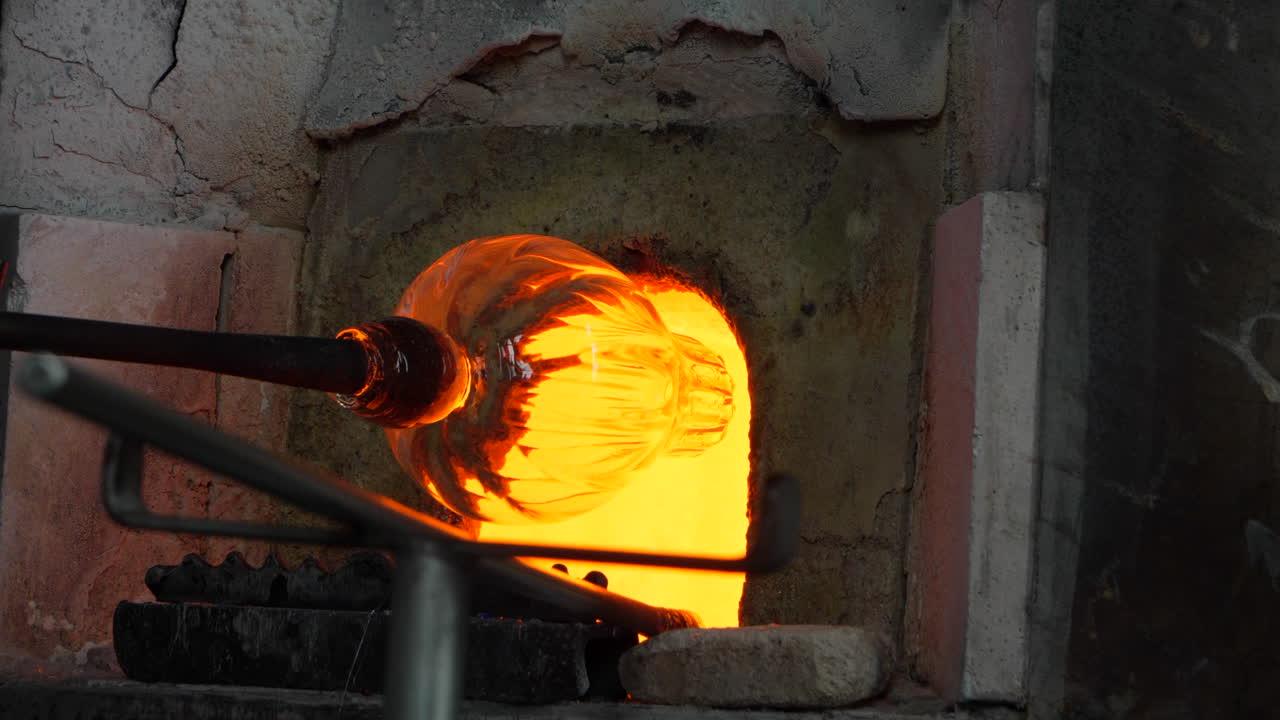 Shaping a blown glass vase in a kiln at a demonstration in Murano.
