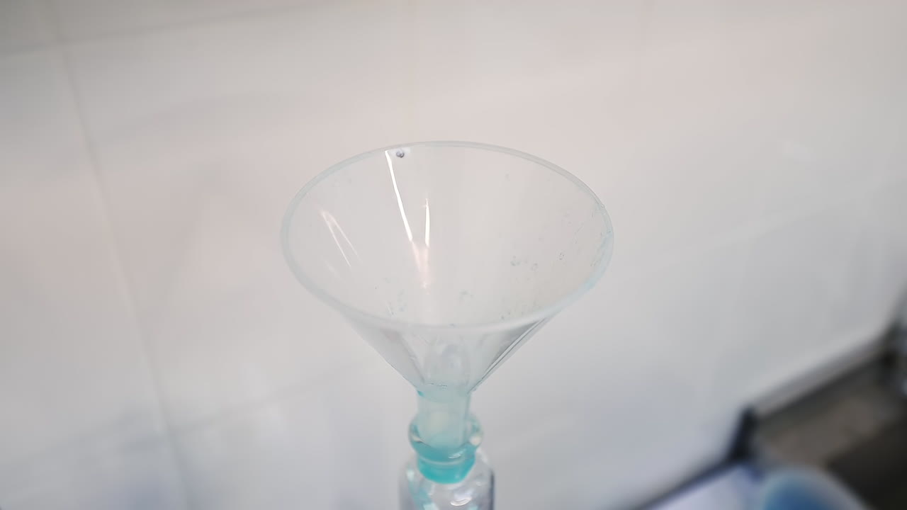 Researcher pours blue liquid into watering can placed in the bottle. Examination of diapers in the enterprise.