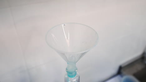 researcher pours blue liquid into watering can placed in the bottle. examination of diapers in the enterprise.