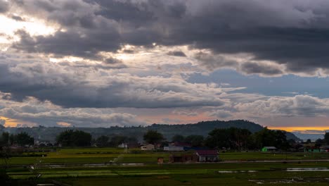 dramatic cloudy sky over rural fields and village