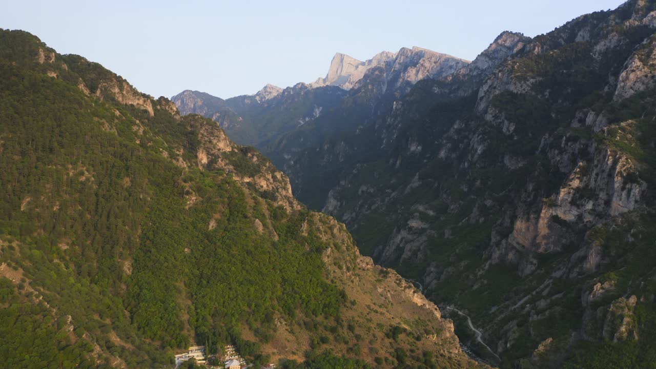 아래로 흐르는 강과 배경에 산봉우리가 있는 협곡의 공중 드론 공개